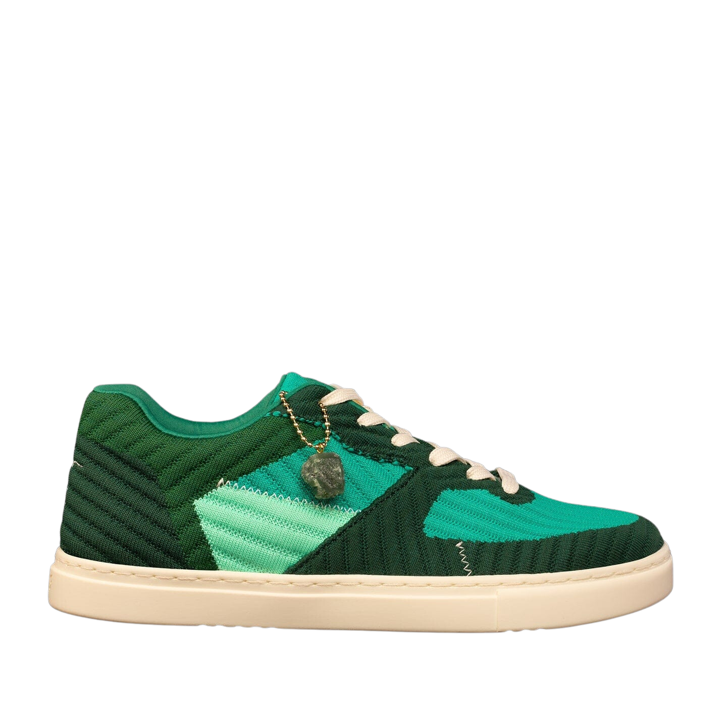 Die Fuego Jade Dance Sneakers in Grün verfügen über geometrische Muster, einen Anhänger, weiße Schnürsenkel und eine beige Sohle aus recyceltem Kunststoff.
